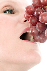 Image showing  woman eating fresh red grapes