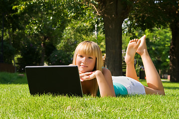 Image showing Young girl on the grass with notebook