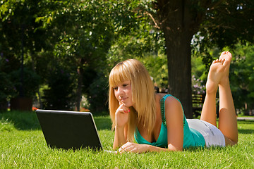 Image showing Young thoughtful girl on the grass with notebook