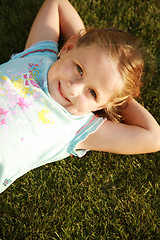 Image showing Happy girl relaxing on a grass