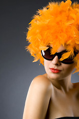 Image showing pretty woman wearing an orange feather wig and sunglasses