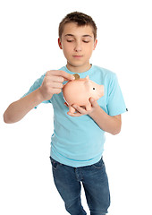 Image showing Child placing coins into a piggy bank