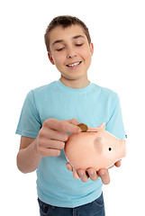 Image showing Boy dropping coin into money box