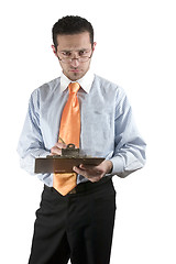 Image showing Businessman looking over his glasses with clipboard on hand