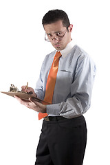 Image showing Businessman looking over his glasses with clipboard on hand - fr