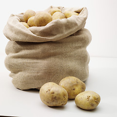 Image showing overflowing bag of potatos on whit