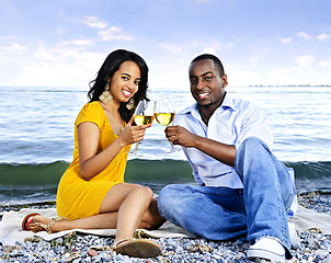 Image showing Happy couple having wine on beach