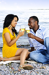 Image showing Happy couple having wine on beach