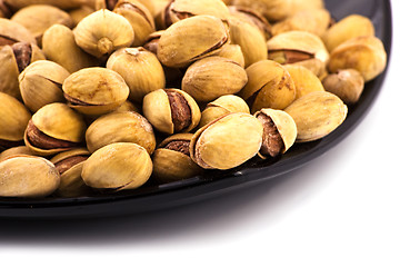 Image showing Iranian salted pistachio in dark plate