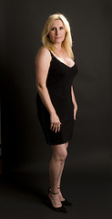 Image showing glamorous middle age woman posing in black dress