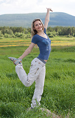 Image showing Beautiful girl stand on one leg in green field