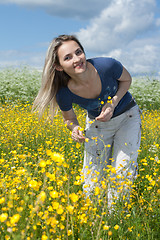 Image showing Beautiful girl in field with yellow flower