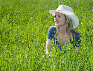 Image showing Girl smiles in hat on the green herb