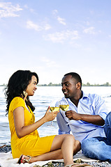 Image showing Happy couple having wine on beach