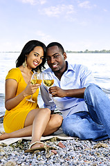 Image showing Happy couple having wine on beach