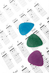 Image showing Colorful guitar picks on a chords chart