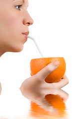 Image showing Pretty girl drink orange juice on white