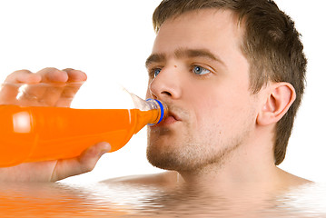 Image showing Young man drinking orange juice