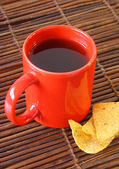 Image showing Red mug and chips on glass plate