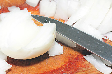 Image showing Cutting onion on the wooden board