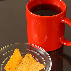 Image showing Red mug and chips on glass plate