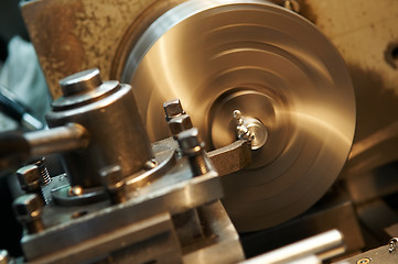 Image showing facing metal blank by cutter on lathe