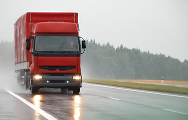 Image showing Red lorry on wet road