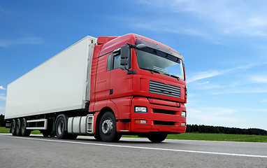 Image showing red lorry with white trailer over blue sky