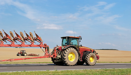 Image showing Tractor moving plough on the road