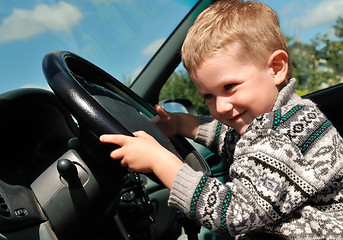 Image showing smiling boy and steering wheel