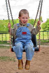 Image showing boy is playng on the swings