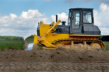 Image showing bulldozer in fields over blue cloudy sky