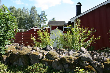 Image showing Stone wall by summer house