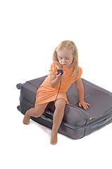 Image showing Little girl and suitcase in studio