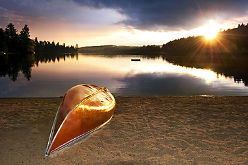 Image showing Lake sunset with canoe on beach