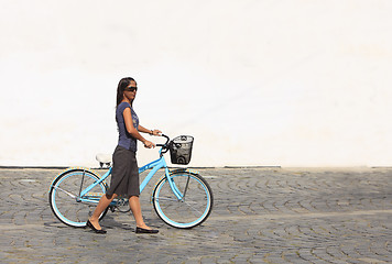 Image showing Woman with a bicycle in a city