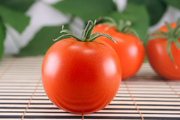 Image showing Three tomatoes on bamboo napkin