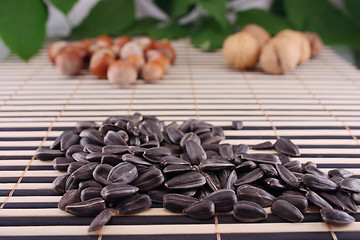 Image showing Sunflower seeds on a striped bamboo napkin