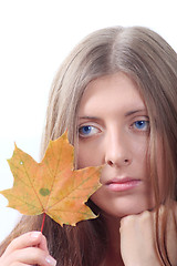 Image showing The thoughtful girl with maple autumn sheet