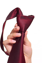 Image showing Female hand holding a red striped tie with the fastened knot