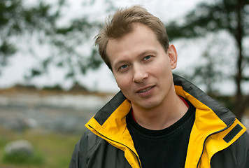 Image showing Man in yellow jacket smiles