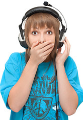 Image showing Beautiful girl in earphone closes mouth by hand
