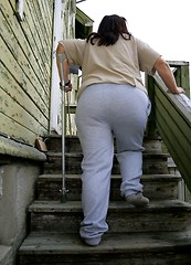 Image showing Poor obese woman with a crutch