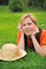 Image showing Young woman laying on the grass