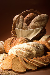 Image showing assortment of baked bread over brown background