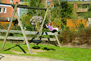 Image showing Small girl on playground swing