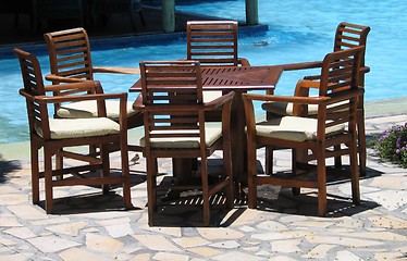 Image showing Complete furniture set by the swimming pool at a resort on a sunny day