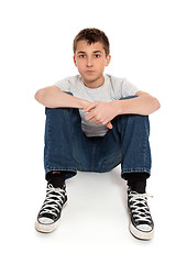 Image showing Pre teen boy sitting in jeans and t-shirt