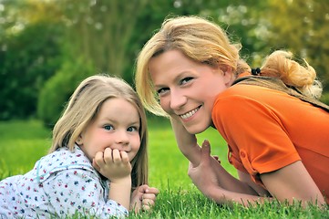 Image showing Young mother and daughter laying on the grass