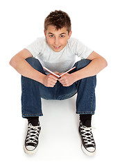 Image showing Boy in jeans sitting on floor